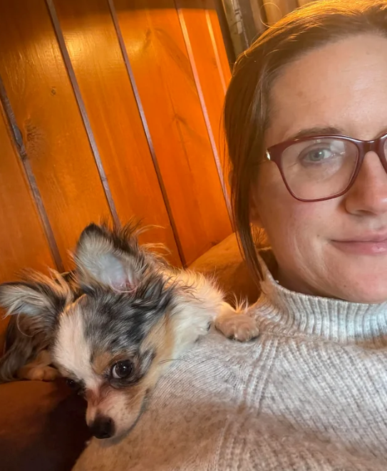 Clienta cargando a su perro pequeño
